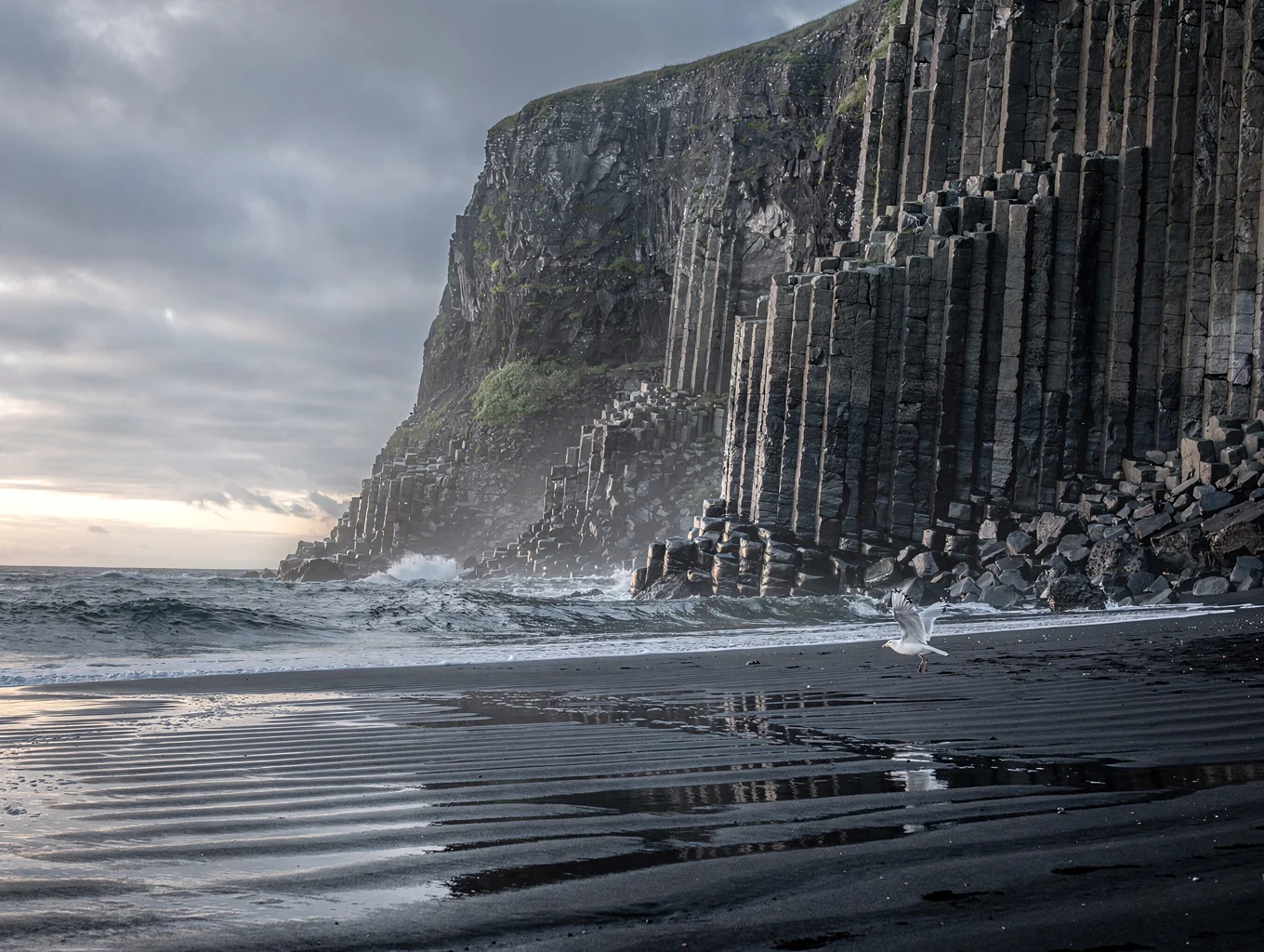 Black volcanic basalt columns on an Icelandic beach at dawn
